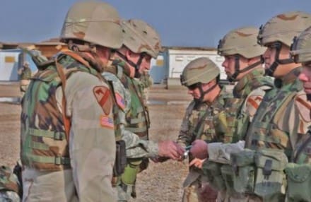 Spc. Anthony Page from Hinckley, Ohio with Company A, 615th Aviation Support Battalion, 4th Brigade Combat Team, 1st Cavalry Division is handed his reenlistment certificate and documents by Army Chief of Staff, Gen. Peter J. Schoomaker during an award and reenlistment ceremony on Camp Taji, Dec 26. (US Army Cpl. Benjamin Cossel, 122nd MPAD)