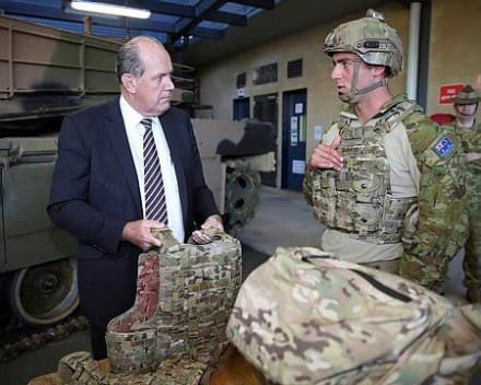 Defence Minister, Senator David Johnston (left), tries the Army's new tiered body armour system and receives a briefing on its capabilities from Australian Army soldier Lance Corporal Aaron Williams from 1st Battalion, Royal Australian Regiment, at the Australian Defence Force Academy on 28 August 2014. 